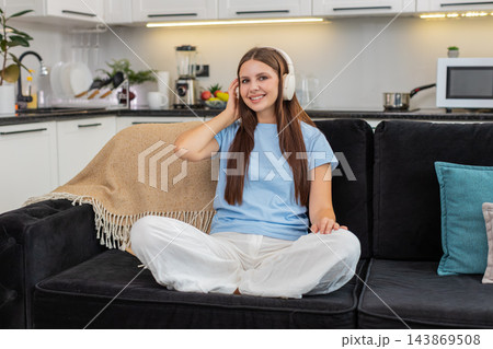Young woman relaxes with wireless headphones listens to favorite music rests eyes calm and peaceful Young woman relaxes with wireless headphones listens to favorite music rests eyes calm and peaceful 143869508