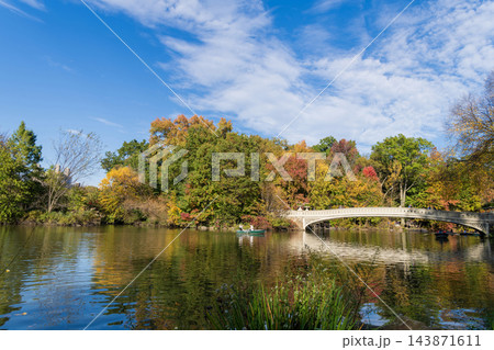 New York City, USA - October 25, 2023: Central Park with boat in lake. Autumn picturesque landscape nature. People rowing boat in Central Park. Central Park with autumn trees. Autumn nature New York City, USA - October 25, 2023: Central Park with boat in lake. Autumn picturesque landscape nature. People rowing boat in Central Park. Central Park with autumn trees. Autumn nature 143871611