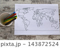 Blank World Map Coloring Page With Colored Markers On Rustic Wooden Table For Geography Study 143872524