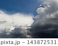 Dramatic contrast between dark thunderstorm clouds and clear blue sky. 143872531
