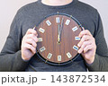Man Holding Vintage Wall Clock Showing Midnight For Time Management And Deadline Concept 143872534