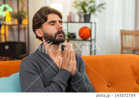 Indian man with closed eyes whispers prayer quiet ask calm mood peaceful hope hands gesture softly Indian man with closed eyes whispers prayer quiet ask calm mood peaceful hope hands gesture softly 143872784