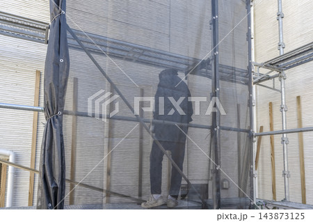 外壁の重ね張りリフォームで下地工事を行う男性職人 外壁の重ね張りリフォームで下地工事を行う男性職人 143873125