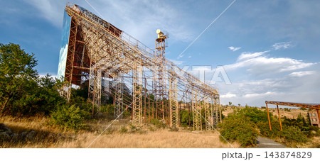 Panorama of rusty steel scaffolding of an unfinished Soviet solar thermal power plant under a cloudy sky, Armenia Panorama of rusty steel scaffolding of an unfinished Soviet solar thermal power plant under a cloudy sky, Armenia 143874829