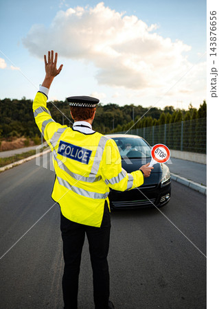 Police officer signaling a driver during a roadside traffic stop Police officer signaling a driver during a roadside traffic stop 143876656