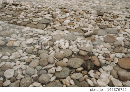 Natural pebbles under clear shallow water, stone texture background Natural pebbles under clear shallow water, stone texture background 143876733