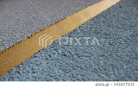 Decorative layer of golden color on porous asphalt surface Decorative layer of golden color on porous asphalt surface 143877035