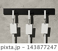 Three blank ID cards on lanyards hanging from a black wall rack on concrete 3D render 143877247