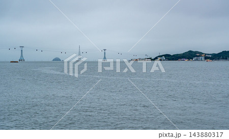 Cable Cars Crossing the Sea Under a Cloudy Sky 143880317