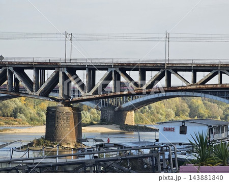 Warsaw, Poland - October 5, 2026: Steel Railway Bridge Spanning the Vistula River in Warsaw Warsaw, Poland - October 5, 2026: Steel Railway Bridge Spanning the Vistula River in Warsaw 143881840