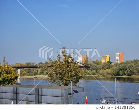 Warsaw, Poland - October 7, 2026: Vistula River and Autumn Waterfront Trees Under Clear Warsaw Sky 143881856