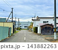 電柱と電線が並ぶ住宅街の細い舗装道路 143882263
