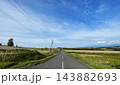 北海道上富良野町・丘陵を走る直線道路とアップダウンの絶景風景 143882693