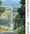 北海道上富良野町・丘陵を走る直線道路とアップダウンの絶景風景 143882694