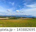 北海道上富良野町・丘陵を走る直線道路とアップダウンの絶景風景 143882695