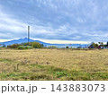 厚い雲の下に広がる秋の草地と遠くの山並み 143883073