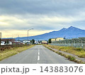 曇り空の下で山並みに向かって伸びる住宅地の道路 143883076