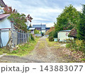 住宅の間を通る砂利道と木々が並ぶ秋の風景 143883077