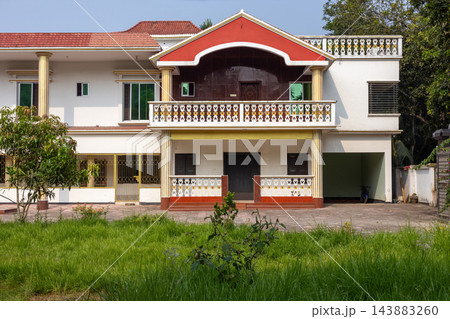 Modern duplex residential house architecture with a green front lawn. Exterior view of a luxury home building in rural countryside setup. Modern duplex residential house architecture with a green front lawn. Exterior view of a luxury home building in rural countryside setup. 143883260