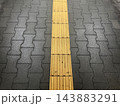 黄色い点字ブロックと舗装路面 143883291