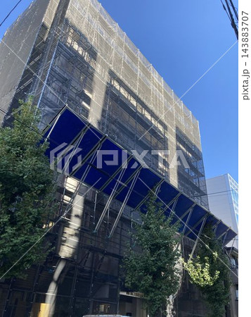 大規模修繕工事中のビルと飛散防止シート・安全朝顔の設置風景 大規模修繕工事中のビルと飛散防止シート・安全朝顔の設置風景 143883707