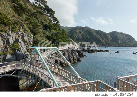 神津島 赤崎遊歩道 崖沿いの木道と入り江　東京都神津島村 143884254
