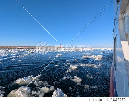 青空の下を進む観光砕氷船から望む流氷と赤い灯台 青空の下を進む観光砕氷船から望む流氷と赤い灯台 143887973