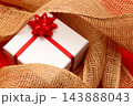ジュート麻に包まれたクリスマスプレゼント 143888043
