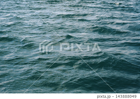 Blue abstract texture with waves on the sea. Background with ocean waves and ripples 143888049