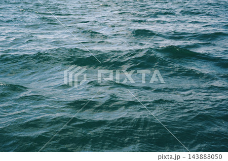 background with blue sea waves on water surface. Texture of the ocean waves. background with blue sea waves on water surface. Texture of the ocean waves. 143888050