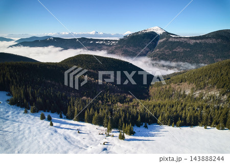 Drone panorama of forested mountains with snow covered meadow 143888244