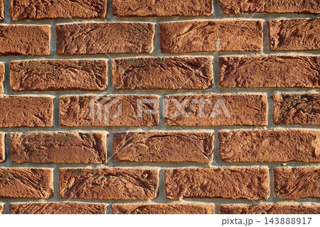 Close-up of rustic textured red brick wall with neat mortar joints 143888917