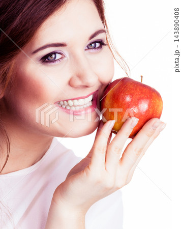Woman holds apple fruit close to face, isolated 143890408