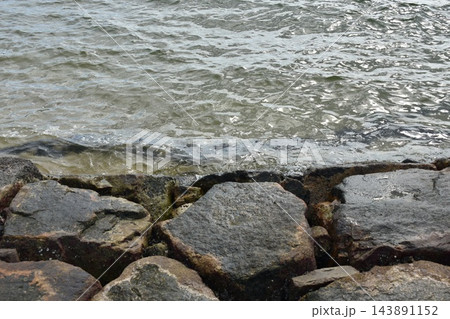 瀬戸内海の海岸で波を受ける護岸の石 瀬戸内海の海岸で波を受ける護岸の石 143891152