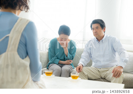 家族会議するシニア夫婦と娘 143892658