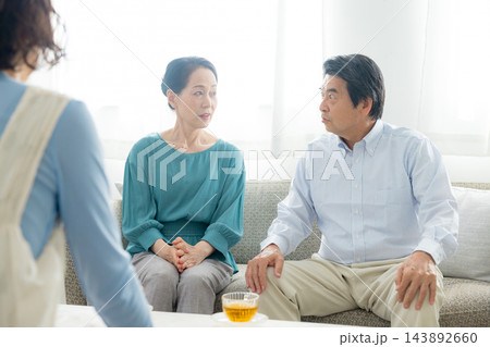 家族会議するシニア夫婦と娘 143892660