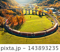 Aerial view of red train on Kreisviadukt Brusio in mountains 143893235