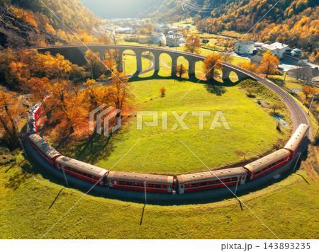 Aerial view of red train on Kreisviadukt Brusio in mountains 143893235
