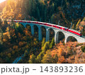 Aerial view of red train on Landwasser viaduct in autumn in Alps 143893236