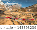 Aerial view of modern red train, alpine mountains, orange meadows 143893239