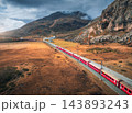 Aerial view of modern red train, alpine mountains, orange meadows 143893243