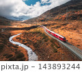 Aerial view of red train, river, mountains, orange hills in fall 143893244