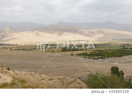 Zarafshan river valley landscape showing dry plain green fields and mountains in Tajikistan Zarafshan river valley landscape showing dry plain green fields and mountains in Tajikistan 143895329