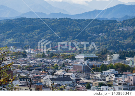 秋の羊山公園からの展望 秩父市街地と山並みに映える赤い巴川橋 アニメの舞台 143895347