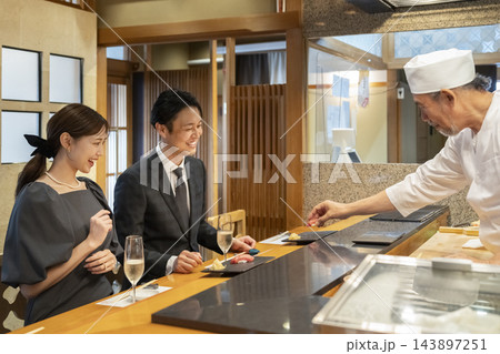 寿司屋のカウンターで食事を楽しむ男女 寿司屋のカウンターで食事を楽しむ男女 143897251