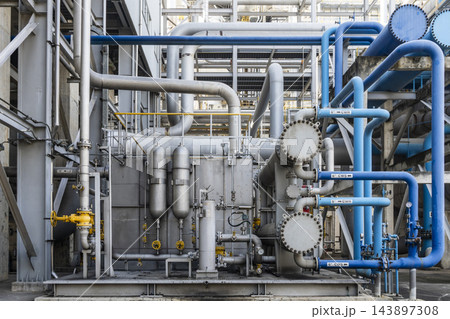 Front view of a well-organized industrial process unit featuring blue cooling water pipelines heat exchangers vertical pressure vessels and yellow valves at a clean petrochemical plant facility. Front view of a well-organized industrial process unit featuring blue cooling water pipelines heat exchangers vertical pressure vessels and yellow valves at a clean petrochemical plant facility. 143897308