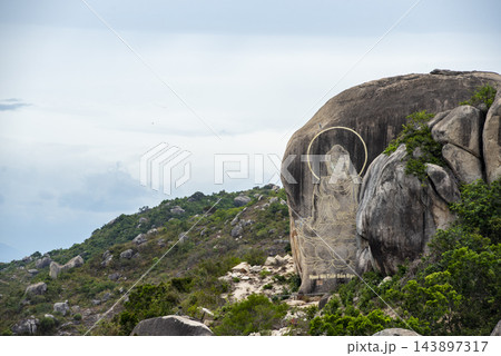 A Buddha carving etched into a massive granite rock on a mountain in Vietnam. A Buddha carving etched into a massive granite rock on a mountain in Vietnam. 143897317