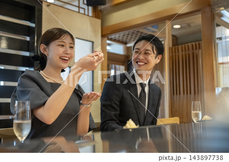 カウンター席で寿司を食べるアラフォーの男女 カウンター席で寿司を食べるアラフォーの男女 143897738