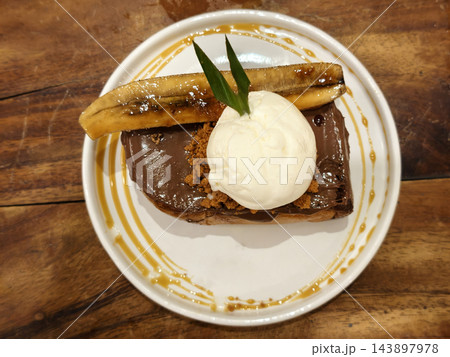 Banana toast with vanilla ice cream and chocolate caramel 143897978