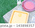 カラフルな食器のある屋外パーティーのテーブル。芝生のある庭。 143898357
